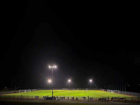 A dynamic soccer field under bright stadium lights with players in action