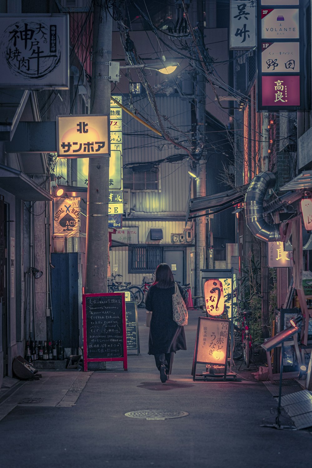 a woman walking down a street at night