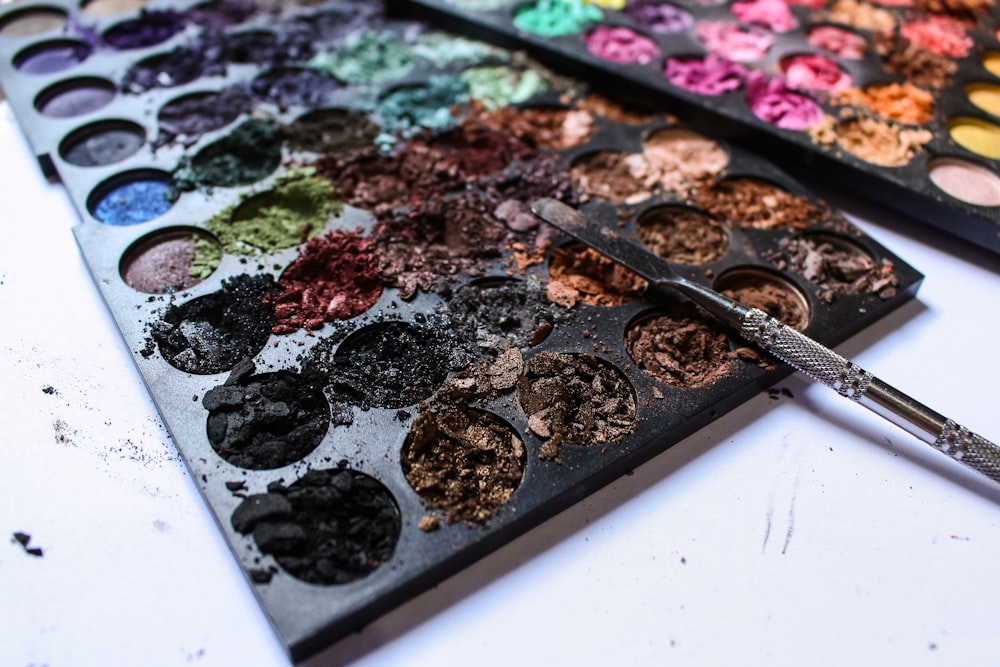 a close up of a palette of paint and a brush