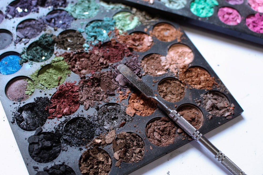a palette of eyeshades and a brush on a table