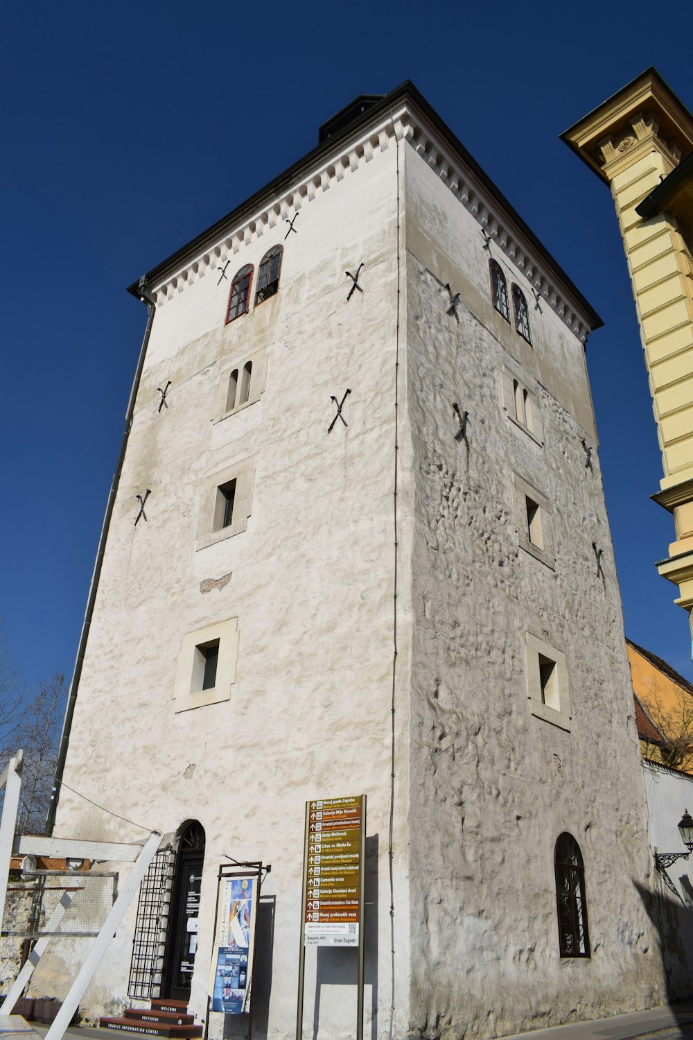 a tall white building sitting next to a tall yellow building