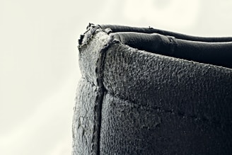 Close-up of a leather motorcycle jacket being hand-stitched by a skilled craftsman.