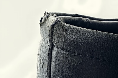 A close-up of a handcrafted leather passport cover with visible stitching and a rich, worn patina.