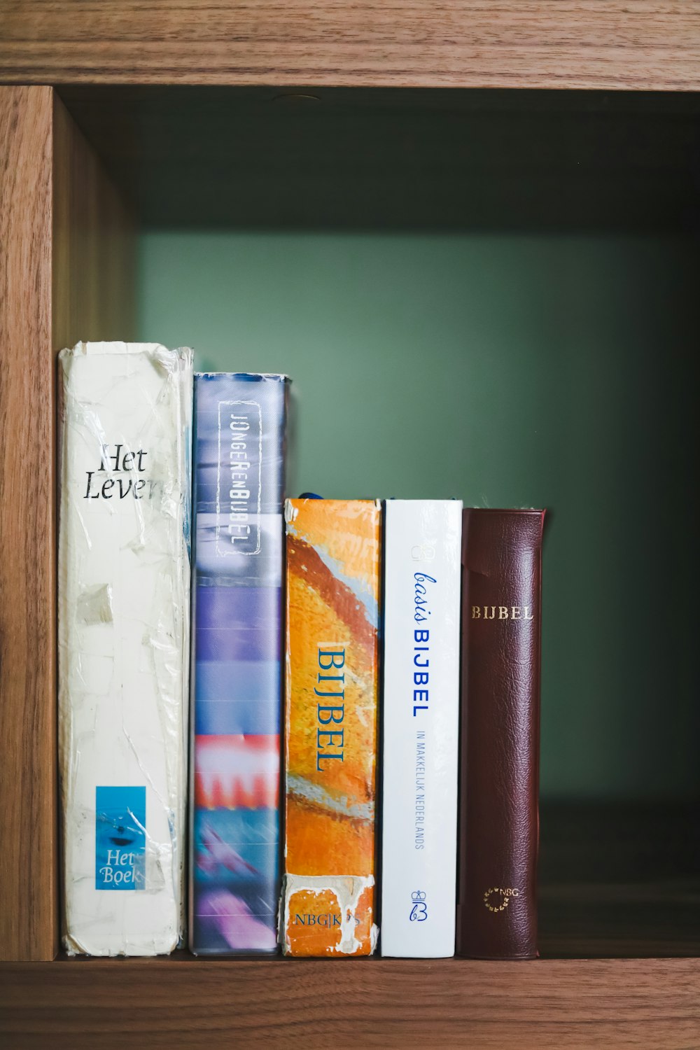 a book shelf filled with books on top of a wooden shelf