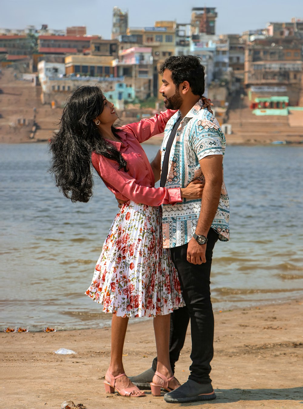 a man standing next to a woman on a beach