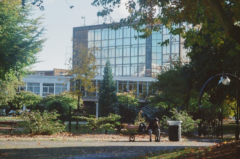 a couple of people sitting on a bench in a park