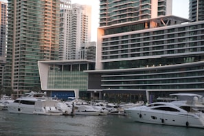 A vibrant Dubai marina scene with yachts docked alongside stylish waterfront properties.