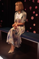 A lifelike sex doll seated elegantly in a softly lit room, highlighting its detailed craftsmanship.