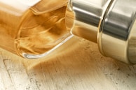 Close-up of a crystal-clear essential oil bottle with a wooden cap, highlighting craftsmanship.