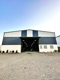 A modern warehouse exterior with a green and white color scheme reflecting the brand colors.