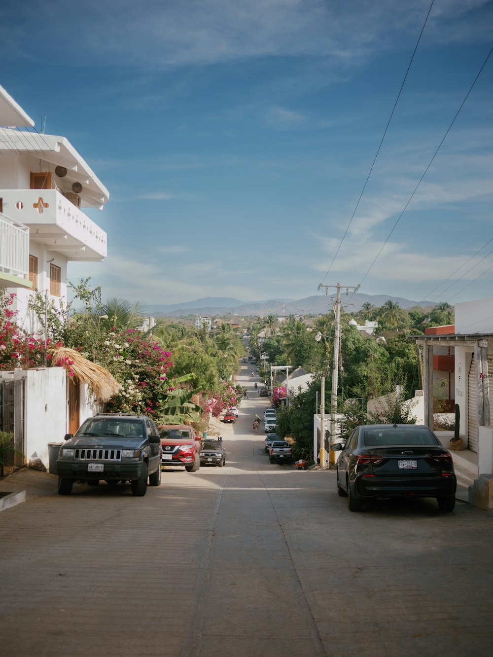 uma rua com carros estacionados em ambos os lados dela