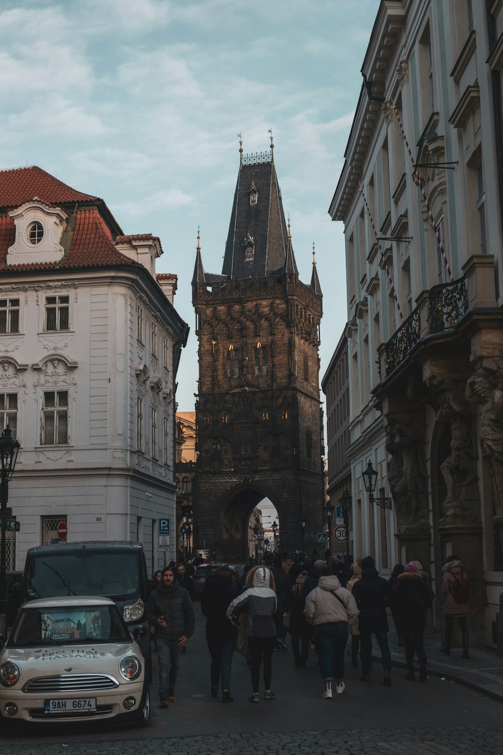 a group of people walking down a street next to tall buildings