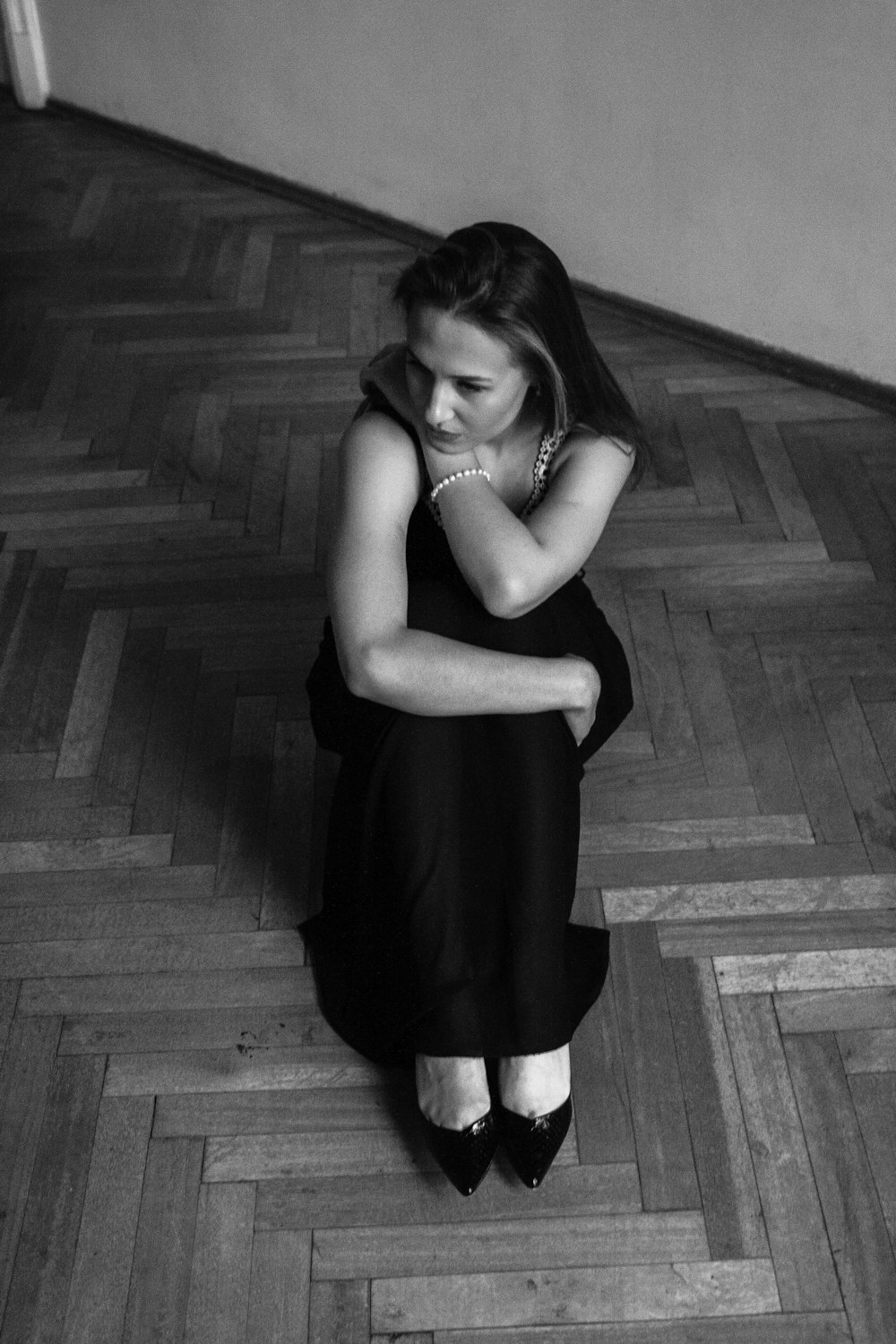 a black and white photo of a woman sitting on the floor