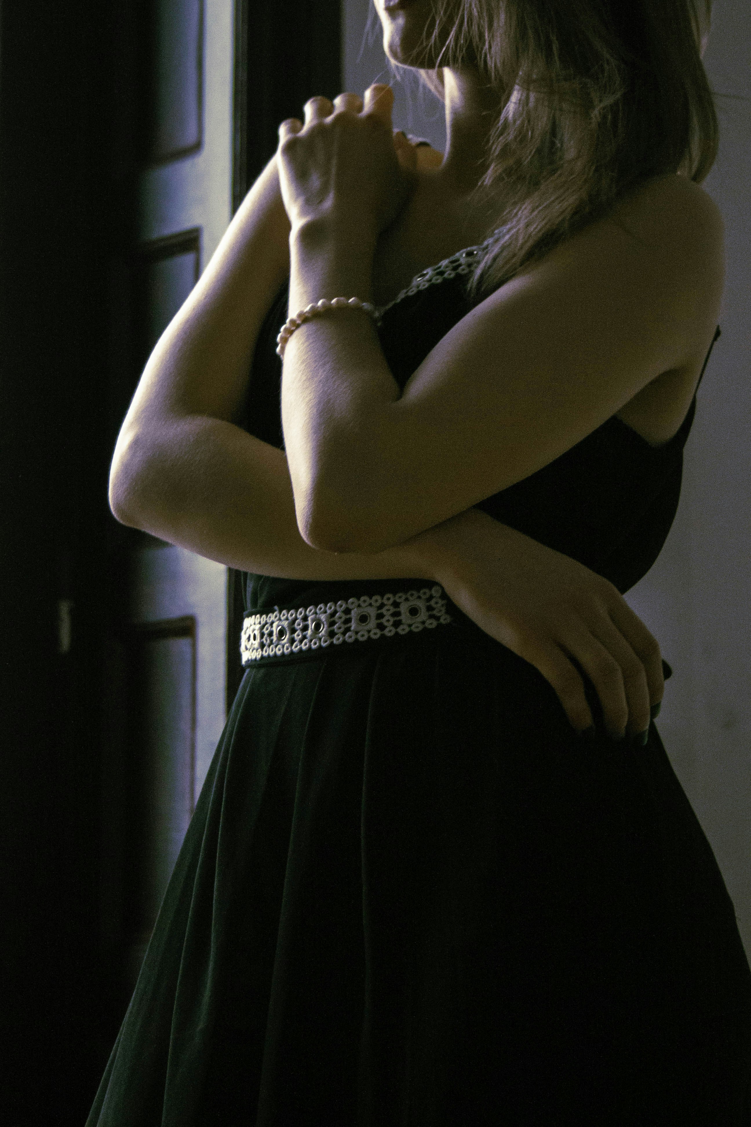 a woman in a black dress with her arms crossed