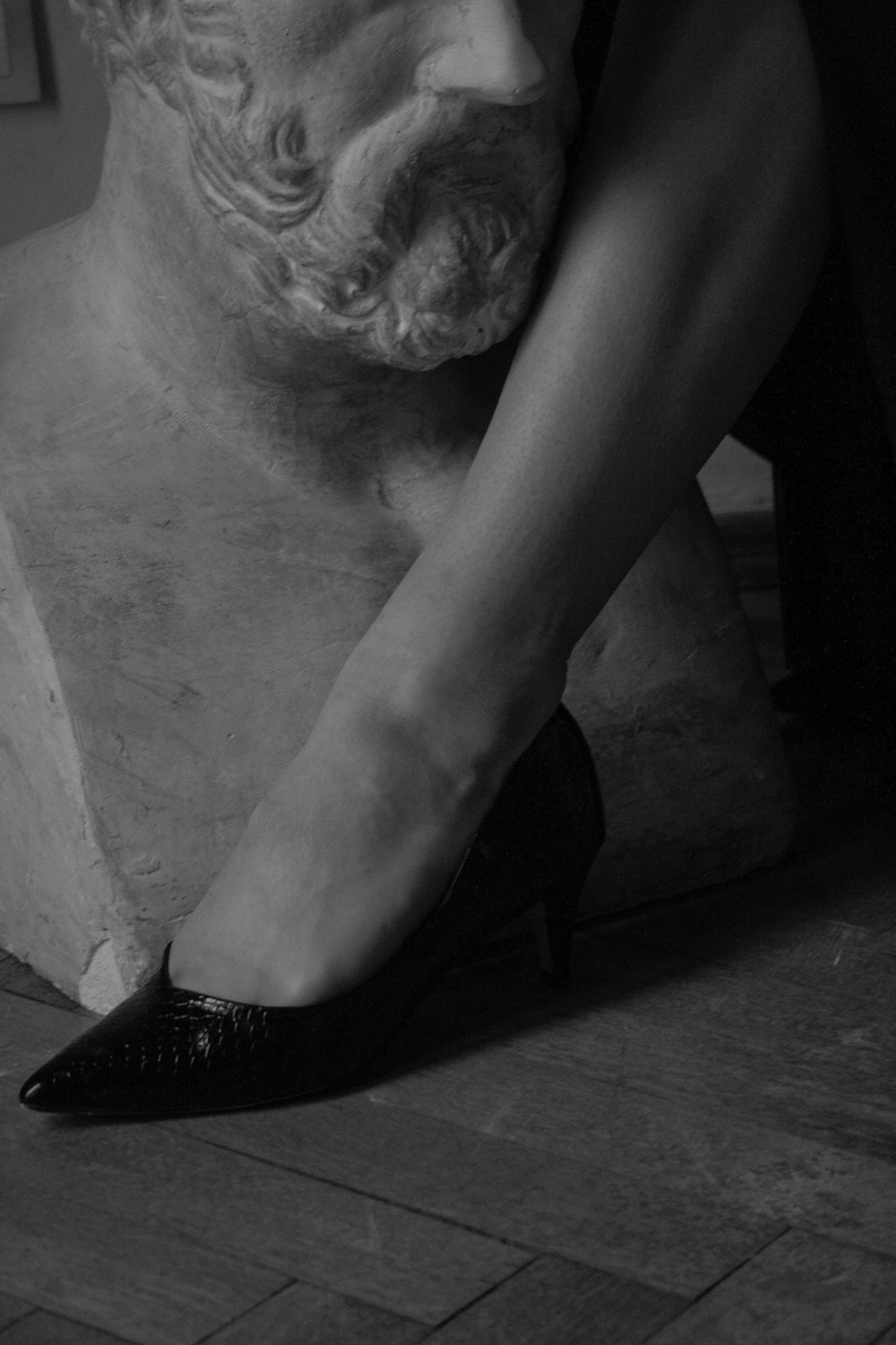 a black and white photo of a woman's legs and shoes