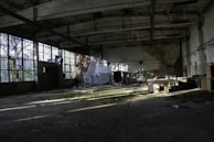 An empty industrial hall bathed in soft natural light, highlighting the silence of abandoned spaces.