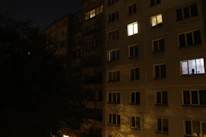 Peaceful night view of the apartment building with soft glowing windows.
