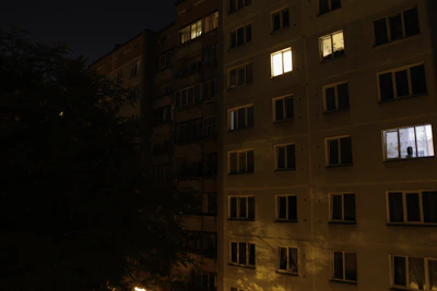 Peaceful night view of the apartment building with soft glowing windows.