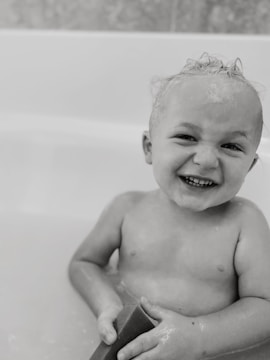 A family happily using Newskin medicated soap in a bright, clean bathroom.