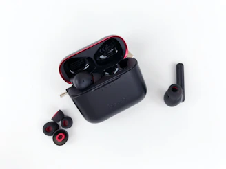 a pair of black earbuds sitting on top of a white surface