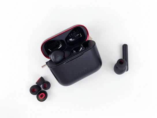 a pair of black earbuds sitting on top of a white surface