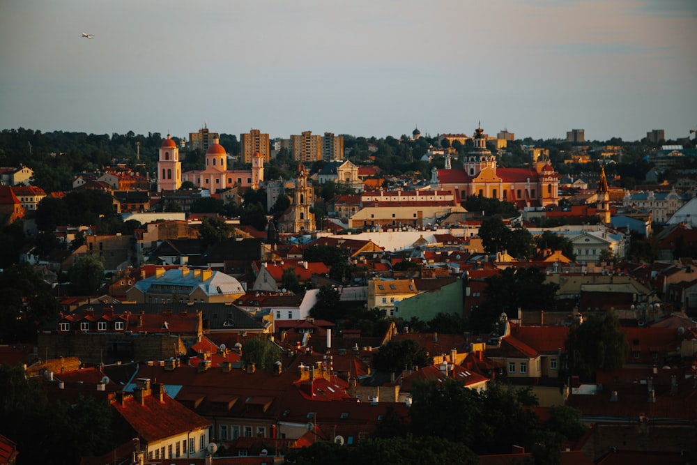 a view of a city with a plane flying in the sky