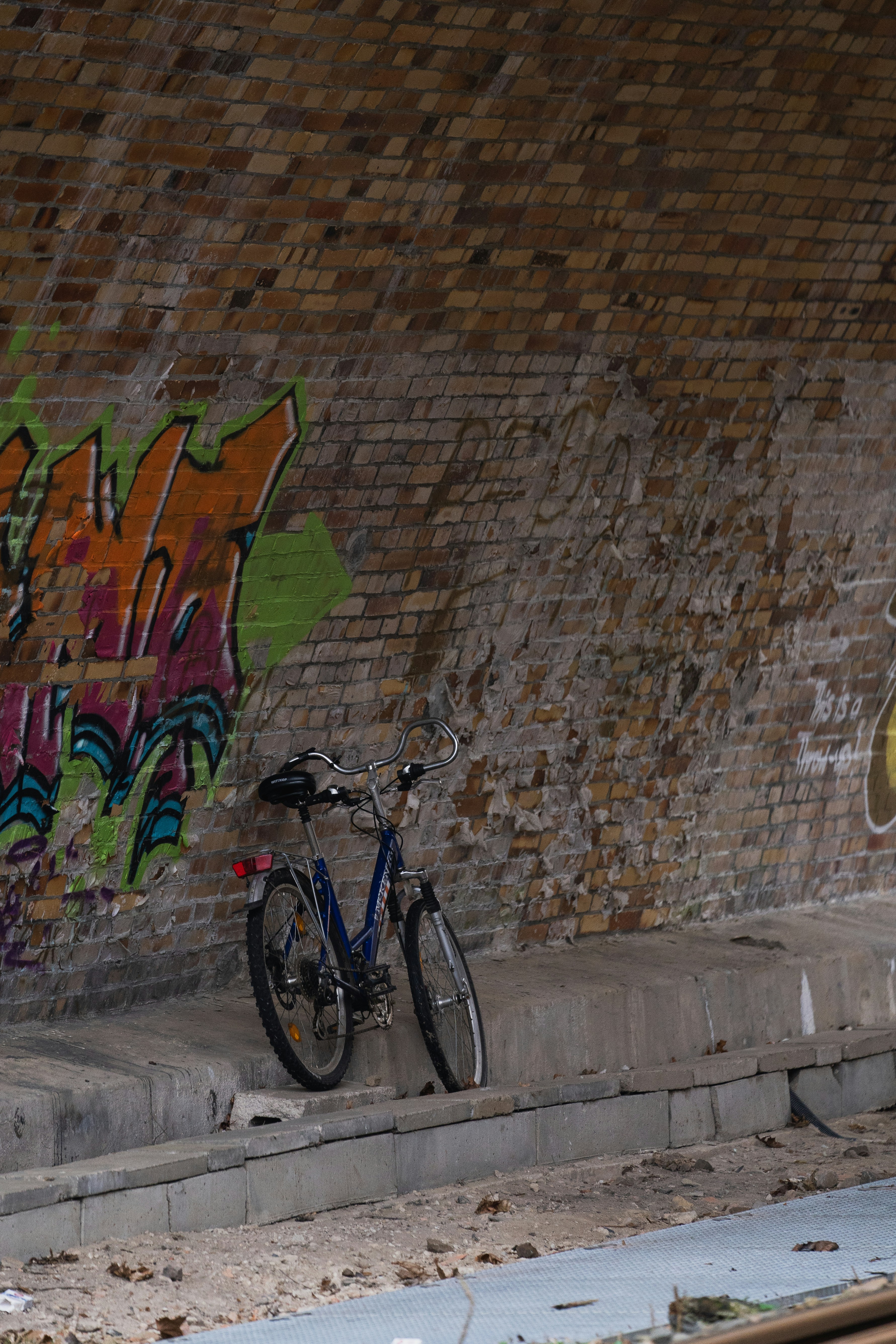 a bike parked next to a wall with graffiti on it