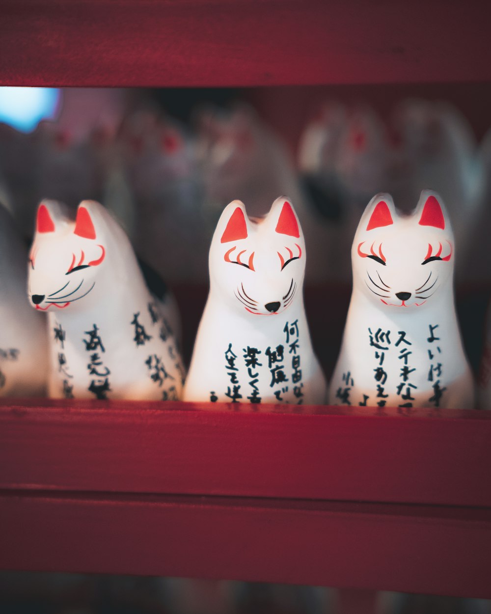 Un grupo de gatos blancos sentados encima de un estante