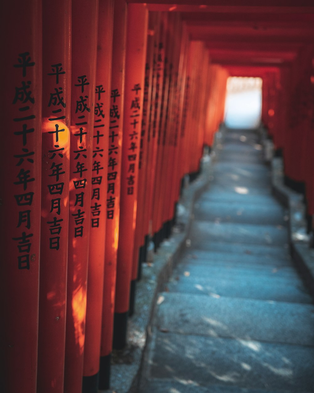 a row of red pillars with asian writing on them
