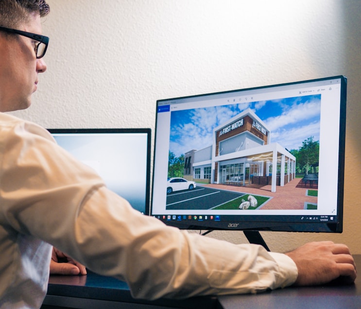 a man sitting at a desk looking at a computer screen