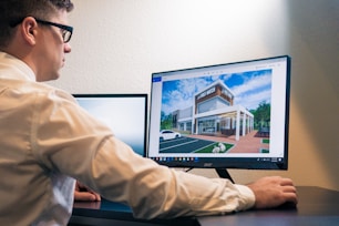 a man sitting at a desk looking at a computer screen
