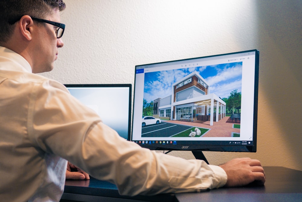 Un hombre sentado en un escritorio mirando la pantalla de una computadora