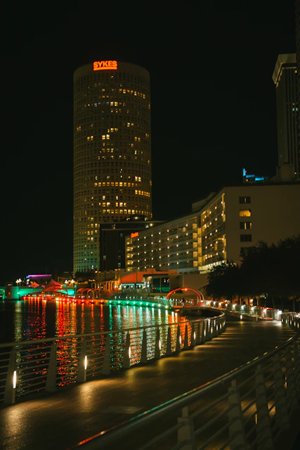 a city at night with lights reflecting in the water