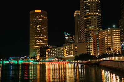 a city at night with lights reflecting in the water