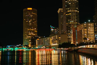 a city at night with lights reflecting in the water