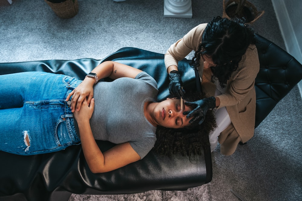 a woman getting her hair done by a hair stylist