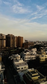 A cityscape showing various types of commercial and residential buildings under a clear sky.