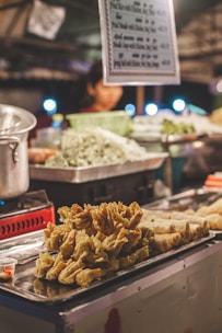 Street-style fried momos sizzling on a grill with vibrant spices and sauces.