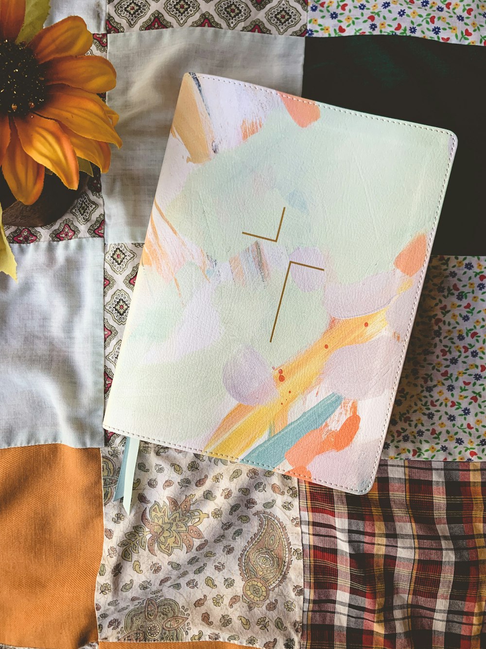 a book with a cross on it sitting on a quilt