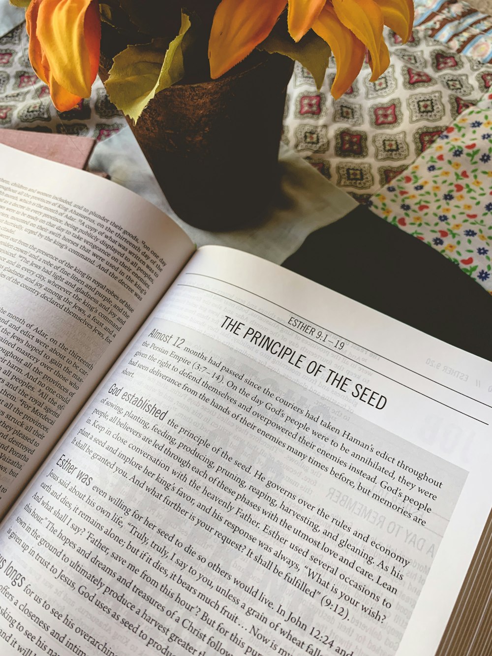 a book opened on a table with a vase of sunflowers