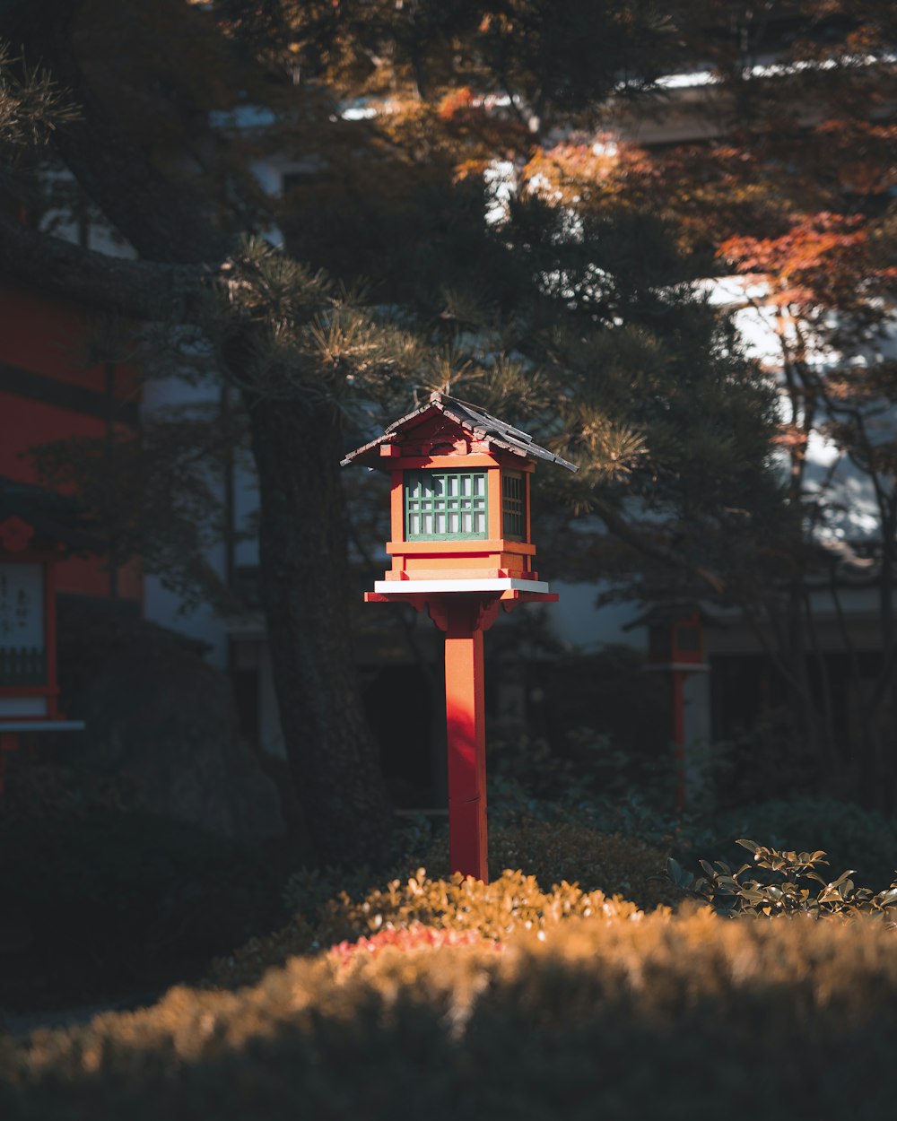 a red clock tower in front of a building