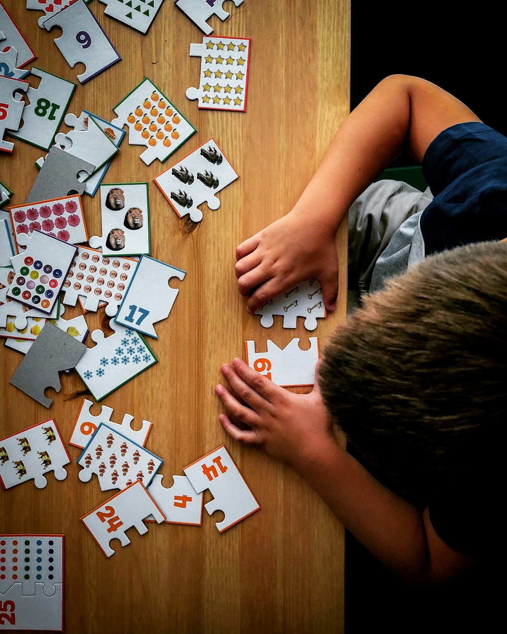 a child is playing with a puzzle on a table