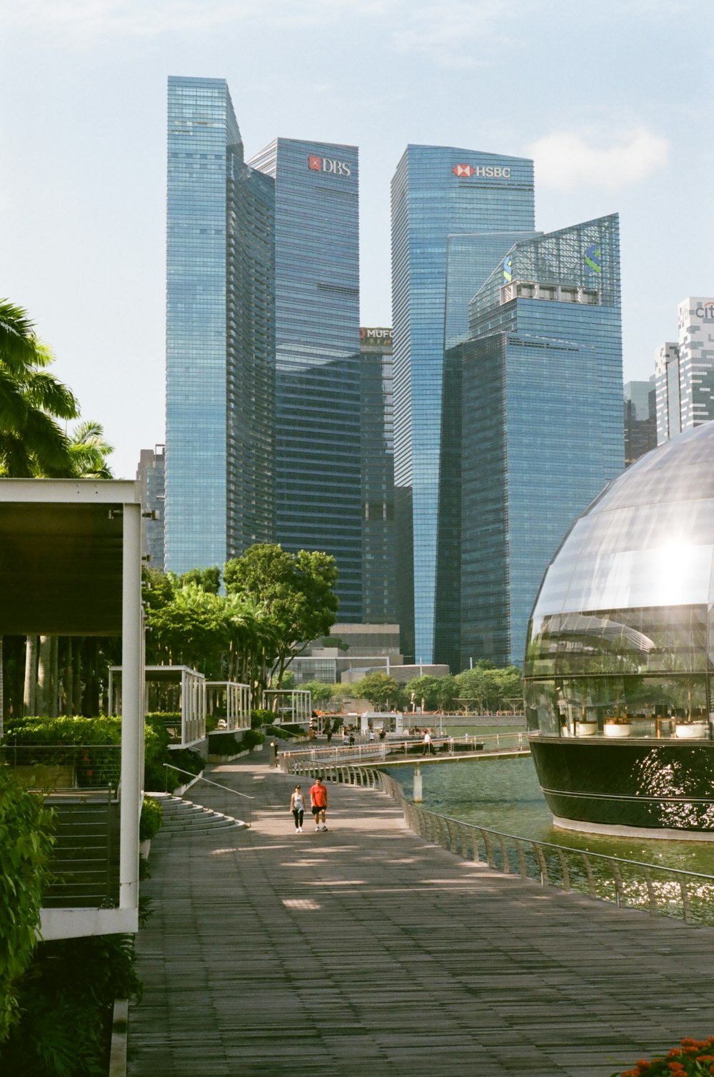 a person riding a bike on a path in front of tall buildings