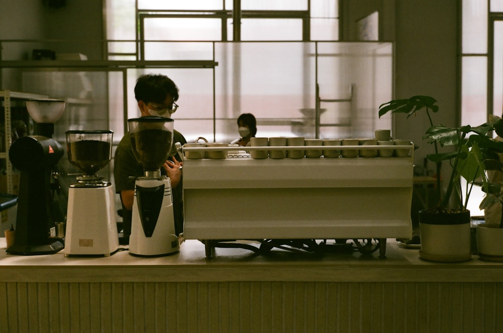 a man standing in front of a coffee maker