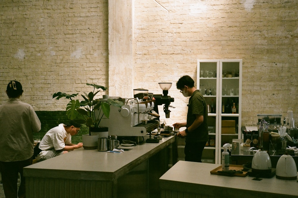 a group of people standing around a kitchen