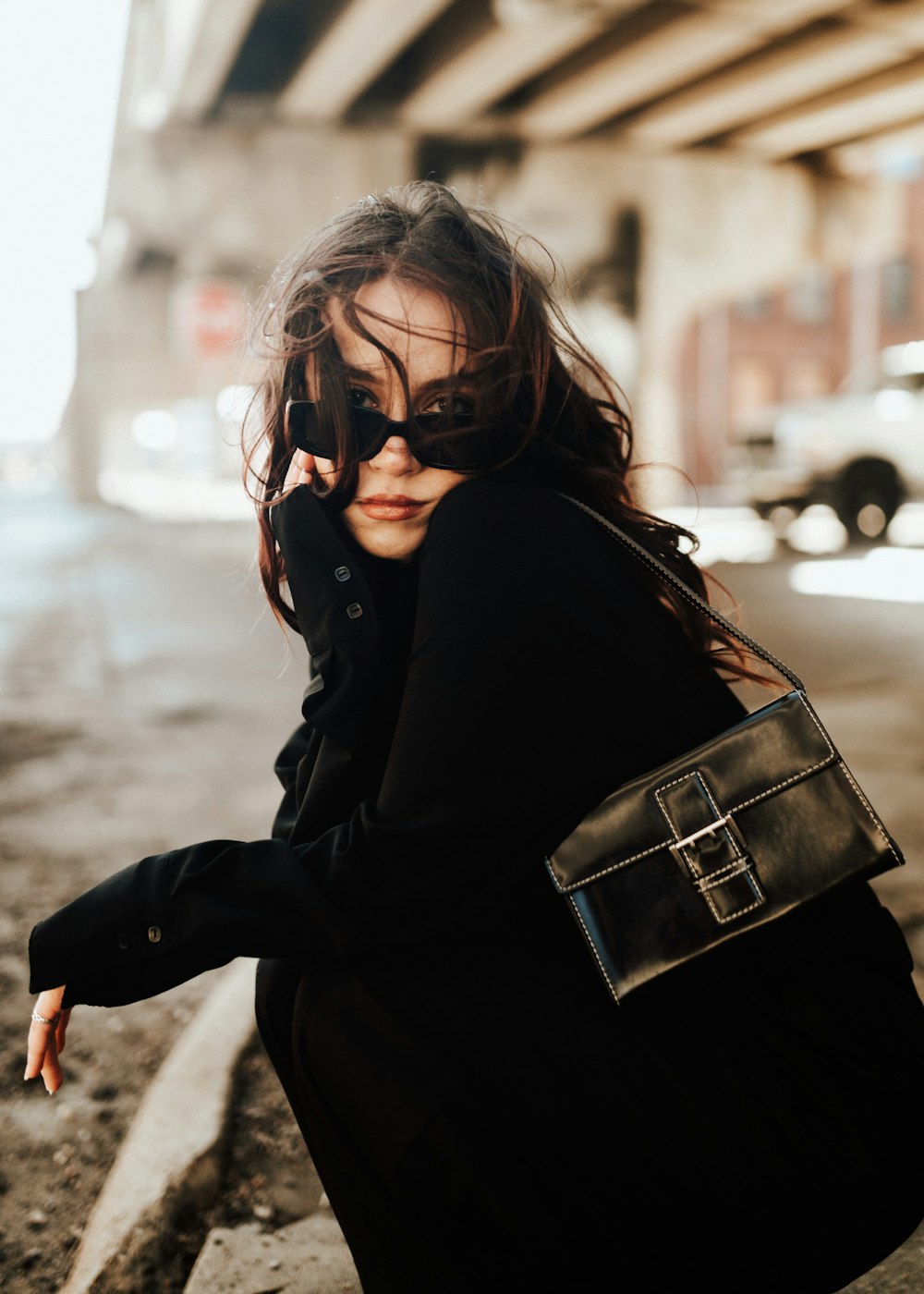 a woman sitting on a curb talking on a cell phone