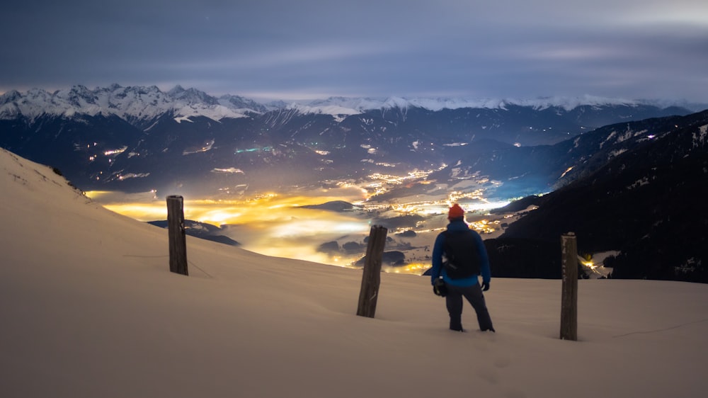 a man standing on top of a snow covered slope