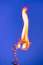 a lit candle with a blue sky in the background