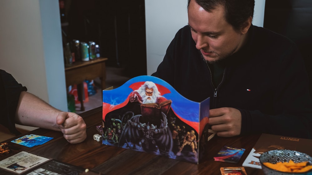 a man sitting at a table looking at a book