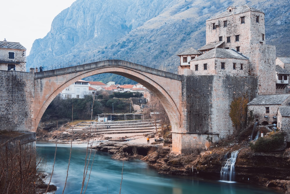 Un puente de piedra sobre un río con una cascada